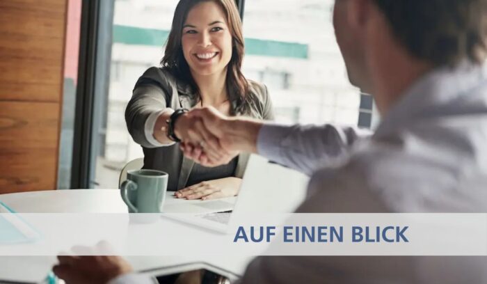 Frau schüttelt über den Tisch die hand ihres neuen Chefs