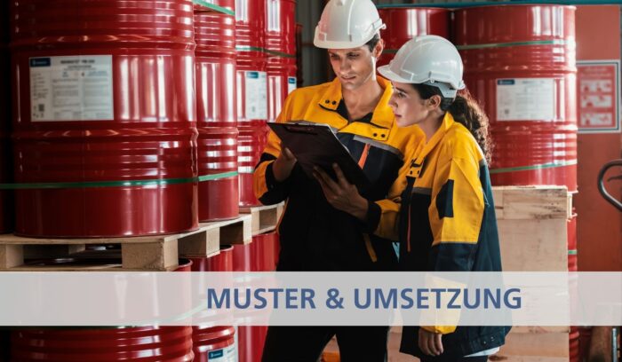 Zwei Mitarbeiter stehen von Fässern mit Gefahrstoffen und besprechen sich